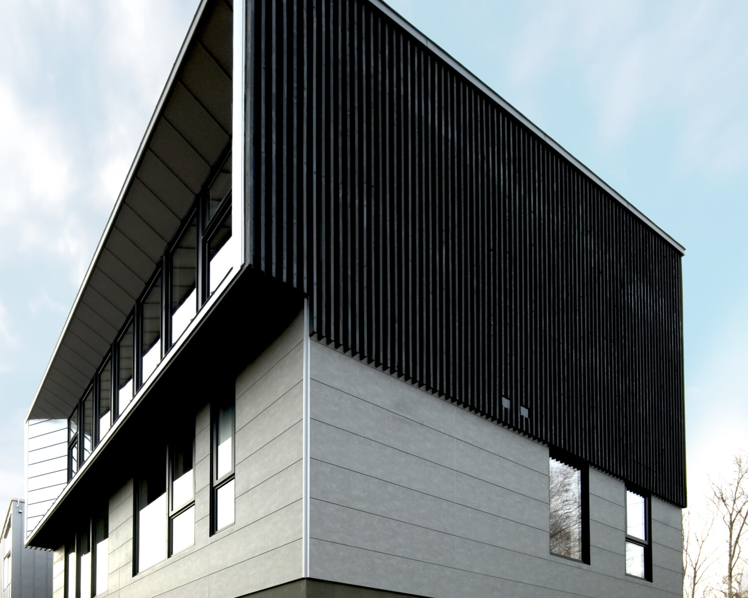 Yugen House architecture photo of a house in Niseko Japan with grey panels and black louvers and large glass portal window